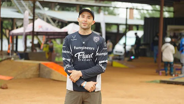 Branden LaCour in his racing jersey beside a racecourse.