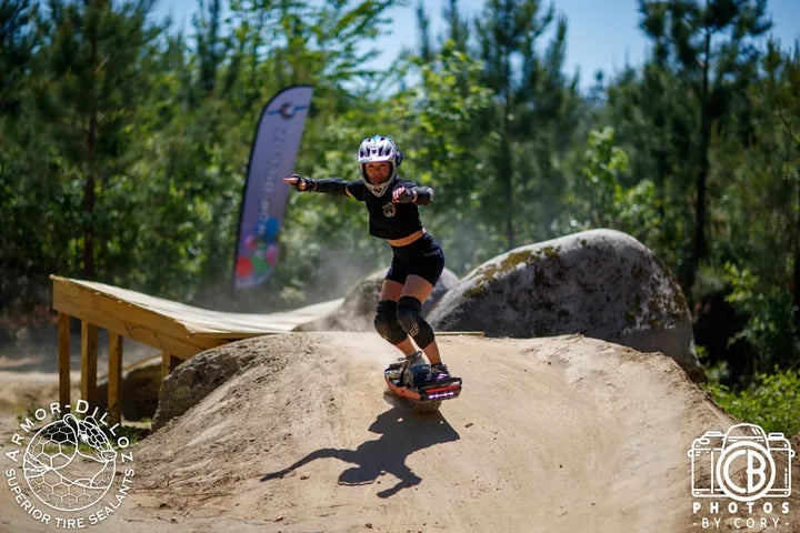 A helmeted rider carving a dirt roller at Oak City Shred Fest.