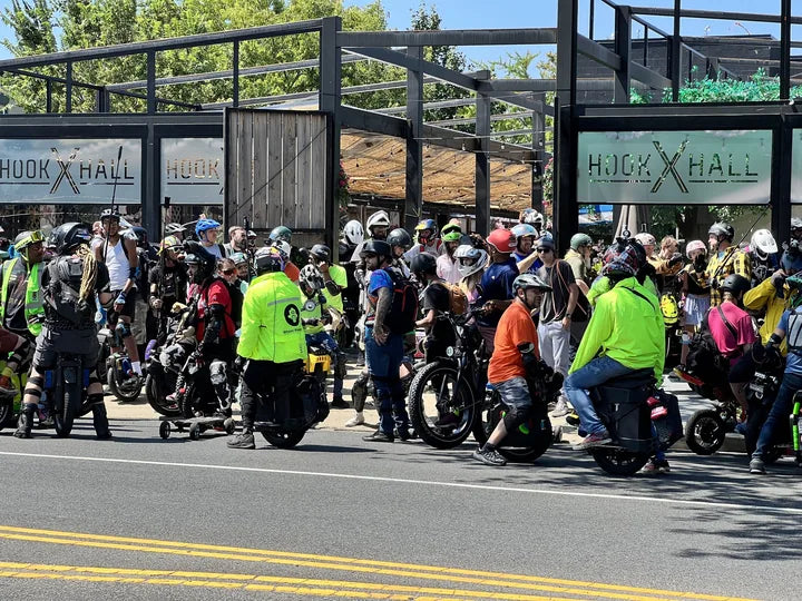 A large group of helmeted PEV riders gathers outside Hook Hall for Groundings D.C.