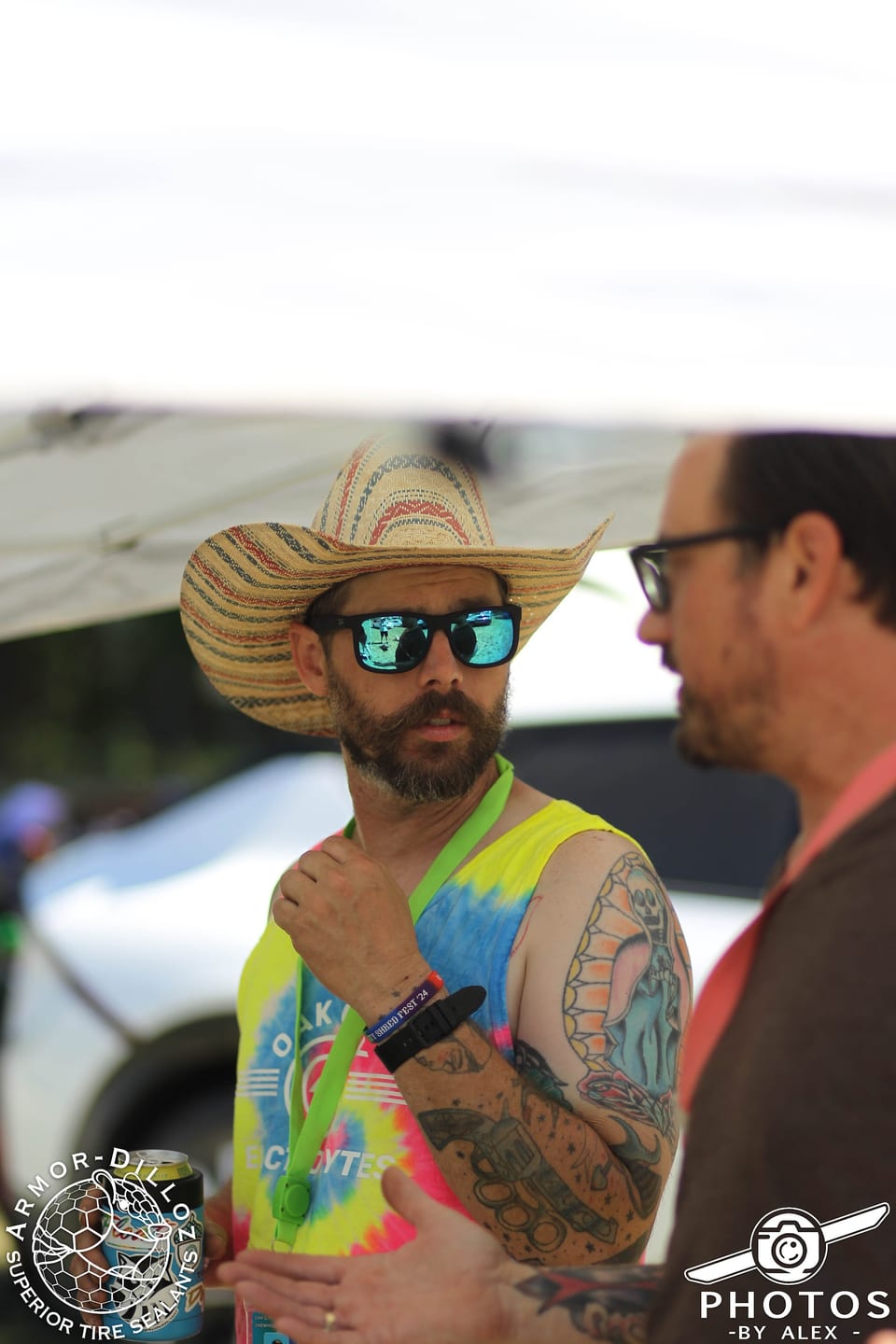 A man in a wide-brim hat and sunglasses talks with another attendee at Oak City Shredfest.