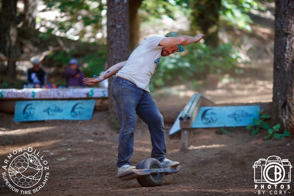 A rider slides a Onewheel along a blue rail at Benwheel Park.