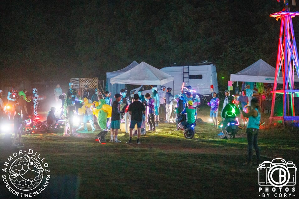 Riders gather around colorful lights and music after dark at Seek N' Shred.