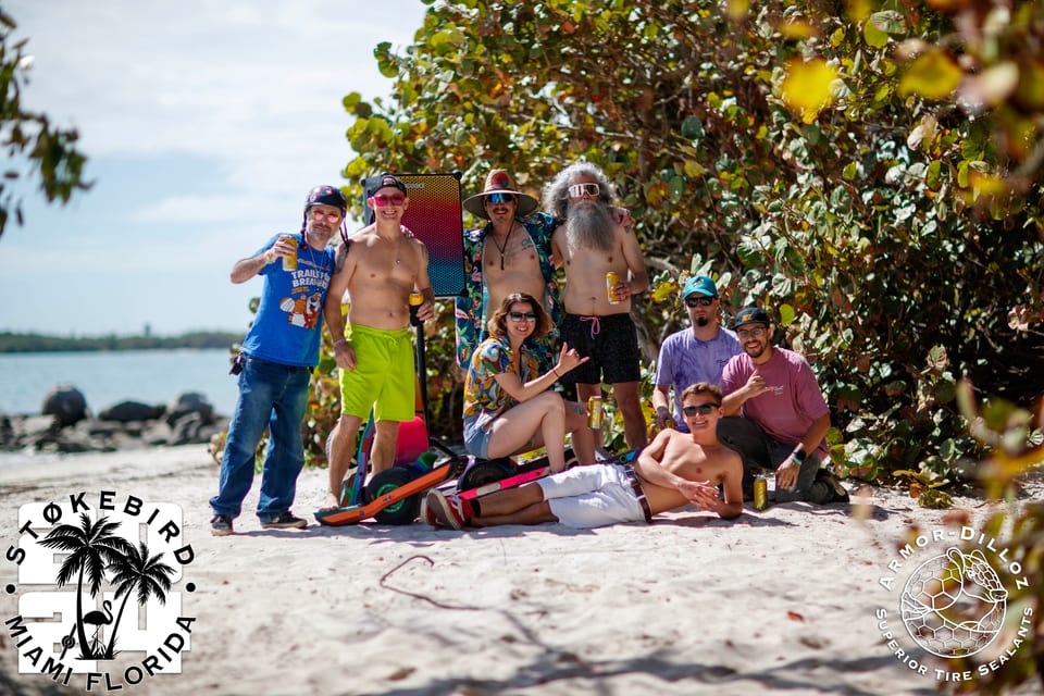 Riders and friends gather beneath a coastal tree during Stokebird.