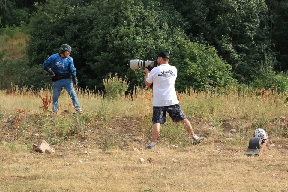 Cory photographing a helmeted rider on a rocky trail, with a Onewheel nearby.